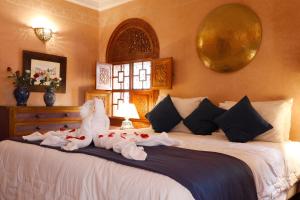a bedroom with a bed with a stuffed animal on it at Riad Daria Suites & Spa in Marrakech