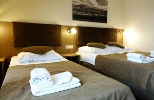Dos camas en una habitación de hotel con toallas. en ZAJAZD BIAŁCZAŃSKI Dom Wypoczynkowy Restauracja, en Białka Tatrzanska