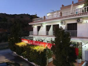 a building with a sign on the side of it at Pension los Verdiales in La Herradura
