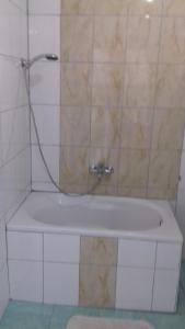 a white bath tub with a shower in a bathroom at APARTMANI LAŠTRO in Jesenice +20 photos