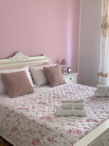 ein Schlafzimmer mit einem großen Bett mit rosa Wänden in der Unterkunft Zá ‘Ntunietta in Portopalo