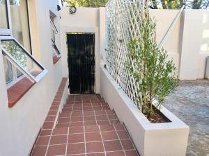 a hallway of a house with a black door and a plant at Kilkenny Cottages 2 bedroom unit in Johannesburg