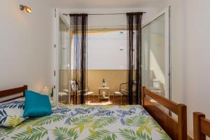 a bedroom with a bed with a blue pillow on it at Apartment- SUNCE in Kaštela