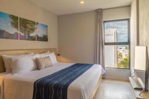 una camera da letto con un letto grande e una finestra di Hotelito del Mar Playa del Carmen a Playa del Carmen Altre 73 foto