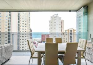 a dining room with a table and chairs and a large window at MIRADOR DE CALPE in Calpe