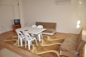 ein Wohnzimmer mit einem Tisch, Stühlen und einem Sofa in der Unterkunft Oz Ulutas Apart Evleri in Finike