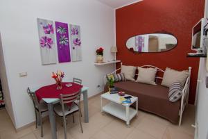 een woonkamer met een bank, een tafel en een spiegel bij La Casa sul Viale in Siracusa