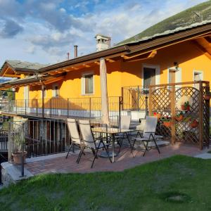 un patio con mesa y sillas frente a una casa en maison Venoir2 en Aymavilles