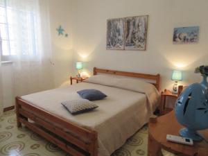 a bedroom with a bed with two lamps and a table at Villa Oltremare in Punta Prosciutto