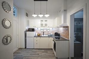 a white kitchen with a sink and a refrigerator at Standard Apartment by Hi5 -Akácfa 57 in Budapest
