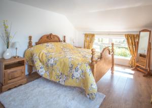 a bedroom with a bed with a yellow bedspread and a window at Mallard Cottage in Whitehead