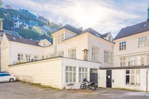 Ein Motorrad, das auf einem Parkplatz vor einem Gebäude abgestellt ist in der Unterkunft Fabryka in Bergen