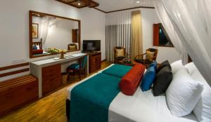カルタラにあるTangerine Beach Hotelのベッドと鏡が備わるホテルルーム