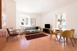 ein Wohnzimmer mit einem Sofa, einem Tisch und Stühlen in der Unterkunft Sonder Piazza San Pietro in Rom