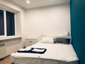 a bedroom with a large white bed with a window at TF Apartment світло 24 на 7 двокімнатні апартаменти в центрі міста in Poltava