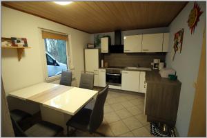una cucina con tavolo e sedie in una stanza di Exklusiver Bungalow direkt am Strand a Dranske