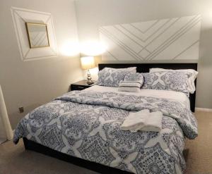 a bedroom with a bed with a blue and white comforter at Inviting Condo in Central Raleigh in Raleigh