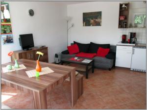 a living room with a couch and a table at Bungalow direkt am Wasser in Stelzendorf