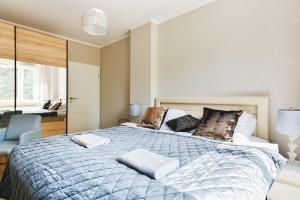 a bedroom with a large bed with two pillows on it at Ursynow P&O Apartments in Warsaw