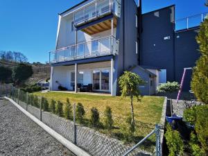 a house with a fence in front of it at Bjørnestrand Fjordside View in Bergen