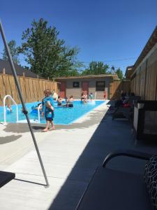 Ein kleines Mädchen steht neben einem Pool in der Unterkunft Jemseg Lakeview Motel in Jemseg