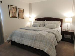 a bedroom with a large bed with two lamps on it at Awesome Condo in Central Raleigh in Raleigh