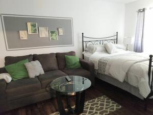 a living room with a couch and a bed at Sweet Nest in Central Raleigh in Raleigh