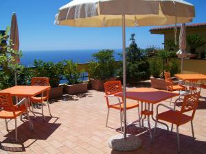 a patio with tables and chairs and an umbrella at Il Mulino in Furore