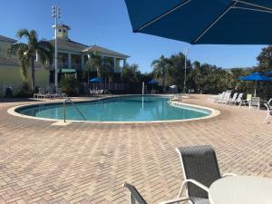 ein Pool mit Stühlen und Sonnenschirmen neben einem Haus in der Unterkunft BAHAMA BAY RESORT in Kissimmee