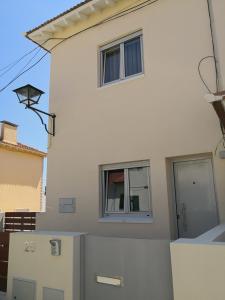 a white house with two windows on the side of it at Be My Neighbour in Lisbon +12 photos
