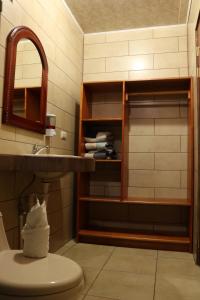 y baño con lavabo, aseo y espejo. en Hotel SueñoReal RioCeleste, en Rio Celeste