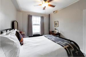 a bedroom with a white bed with a ceiling fan at Hotel Congress in Tucson