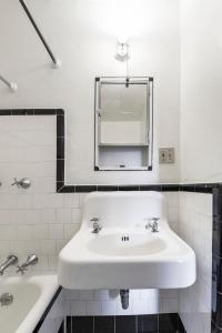 a white bathroom with a sink and a mirror at Hotel Congress in Tucson