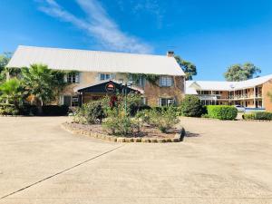 a large brick building with a white roof at Campbelltown Colonial Motor Inn in Campbelltown