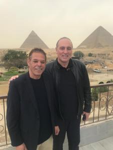 two men standing next to each other in front of a wall at Pyramids View Inn in Cairo