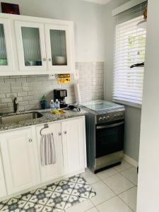 a kitchen with white cabinets and a black oven at Studio 13 in Kingston +8 photos