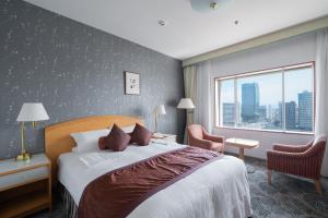 a hotel room with a bed and a window at Hotel Okura Niigata in Niigata