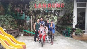 Homestay Lan Rung في Nghĩa Lộ: عائلة تقف لالتقاط صورة أمام متجر