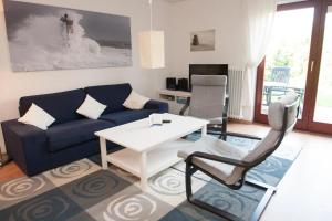 sala de estar con sofá, mesa y sillas en 50155 Haus Mundhenk, en Carolinensiel