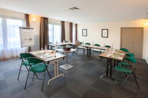 a conference room with tables and green chairs at Campanile Poitiers in Poitiers