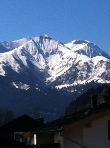 a snow covered mountain in front of a house at Ferienwohnung Zell am See in Zell am See