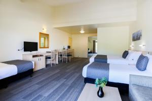 Habitación de hotel con 2 camas y sofá en Parkhaven, en Nowra