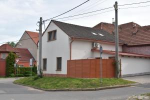 una casa blanca con una valla y algunas casas en Apartmán-Hovorany en Hovorany