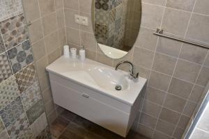 Apartmán-Hovorany في Hovorany: حمام مع حوض أبيض ومرآة