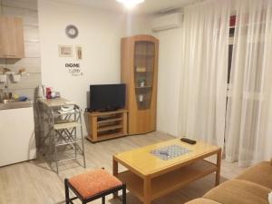 Apartments Duras في Gruda: غرفة معيشة مع تلفزيون وطاولة