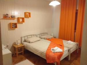 Apartments Duras في Gruda: غرفة نوم بسريرين وبطانية برتقالية