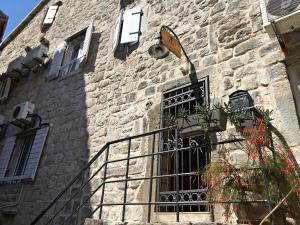 un edificio de piedra con puerta y balcón en Sailor House, en Budva