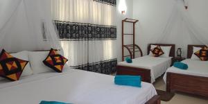 1 dormitorio con 2 camas y 2 sillas en Liyara Home Stay, en Sigiriya