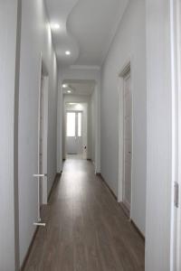 un pasillo vacío con paredes blancas y suelo de madera en Guest House Lviv, en Kutaisi