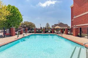 a large swimming pool in front of a brick building at Comfort Suites McKinney-Allen in McKinney